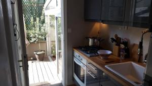 a kitchen with a stove and a sink next to a door at Atout Charme in Versailles