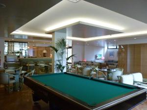 a pool table in a room with a bar at Hotel Marina Uno in Lignano Sabbiadoro