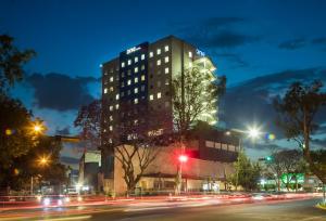 a building on a city street at night at One Guadalajara Expo in Guadalajara