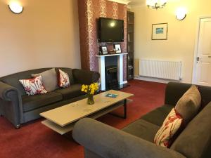 a living room with two couches and a coffee table at The Miclaran in Shanklin