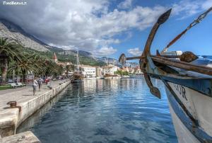 een boot is aangemeerd naast een waterlichaam bij Apartment Mia Makarska in Makarska