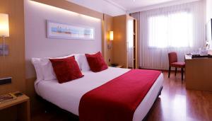 Pokój hotelowy z dużym łóżkiem z czerwonymi poduszkami w obiekcie Abba Rambla Hotel w Barcelonie