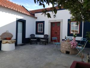 un patio con sillas y una puerta roja en Patio da Memoria, en Palmela