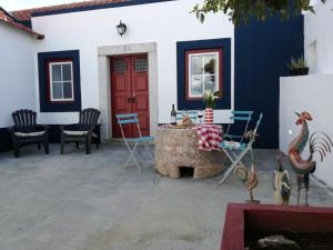 un patio con sillas y una puerta roja en Patio da Memoria, en Palmela