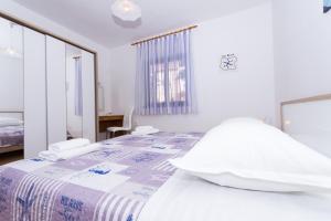 - une chambre blanche avec un lit et un bureau dans l'établissement Apartment Tina, à Trogir