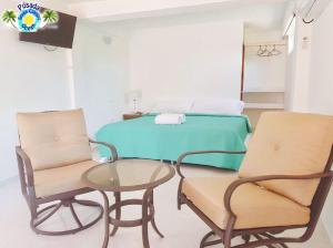 a room with a bed and two chairs and a table at Posada Seven Colours Ocean in Providencia