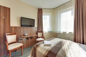 a hotel room with a bed and a television at Abak in Gdańsk