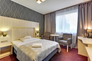 una camera d'albergo con un letto e due sedie di Abak a Danzica