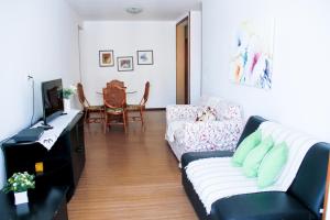 a living room with a couch and a table at Apartamento Varandas Barra Flat in Rio de Janeiro
