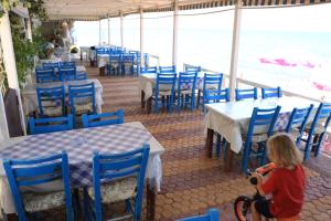 a little girl riding a bike in front of a restaurant at Ocean Bay in Arvi