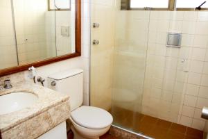 um banheiro com vaso sanitário, pia e chuveiro em Apartamento Varandas Barra Flat no Rio de Janeiro