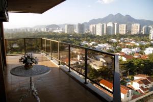 a balcony with a table and a view of a city at Apartamento Varandas Barra Flat in Rio de Janeiro
