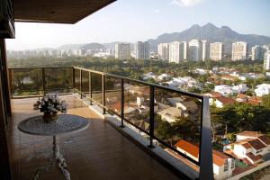 uma varanda com uma mesa e vista para uma cidade em Apartamento Varandas Barra Flat no Rio de Janeiro