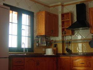 a kitchen with wooden cabinets and a sink and a window at Vivienda Vacacional La Roca in La Restinga