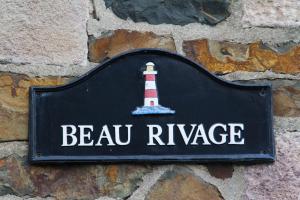 Znak na ścianie z latarnią morską w obiekcie Residence Beau Rivage Brehec w mieście Plouha
