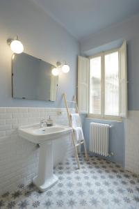 baño con lavabo, espejo y silla en Le camere di Sementis, en Pietrasanta
