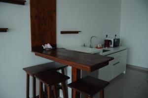 a kitchen with a counter and a sink and stools at Zen Studio @ Trefoil Setia Alam in Shah Alam