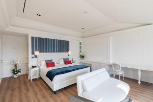 a white bedroom with a bed and a couch at Grand Hotel Palace in Ancona