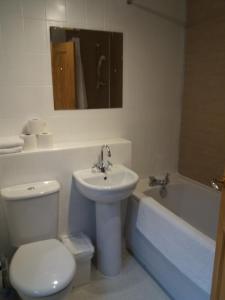 a bathroom with a toilet and a sink and a tub at House for Groups & Contractors Kilmarnock in Kilmarnock