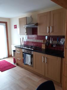 a kitchen with wooden cabinets and a stove top oven at House for Groups & Contractors Kilmarnock in Kilmarnock