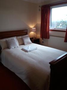 um quarto com uma grande cama branca e uma janela em House for Groups & Contractors Kilmarnock em Kilmarnock