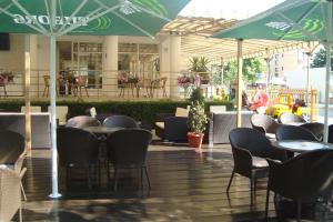 a restaurant with tables and chairs and umbrellas at Hotel Astra in Ravda