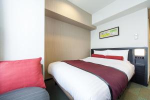 a bedroom with a large bed and a red pillow at MYSTAYS Shin Urayasu Conference Center in Urayasu
