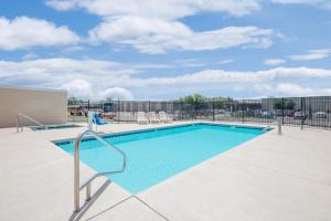 a swimming pool with chairs and a fence at Days Inn & Suites by Wyndham Hutchinson in Hutchinson
