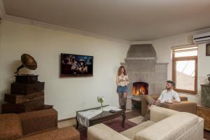 a man and a woman standing in a living room with a fireplace at Royal Stone Houses - Goreme in Göreme