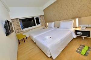 Ένα ή περισσότερα κρεβάτια σε δωμάτιο στο Whiz Prime Hotel Sudirman Cilacap