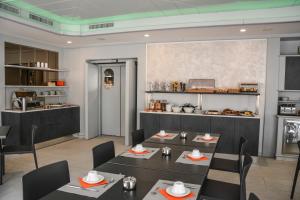 a restaurant with tables and chairs and a kitchen at Hotel Aurora & Appartamenti in Nago-Torbole