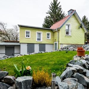 ein gelbes Haus mit einem Hof mit Felsen in der Unterkunft harz-traum in Gernrode - Harz