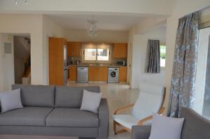uma sala de estar com um sofá e uma cozinha em Anthorina Villa 3 em Protaras