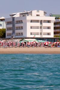 a hotel on the beach with chairs and umbrellas at Hotel Parigi in Caorle