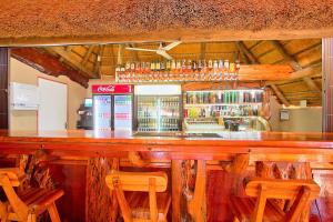 a bar in a restaurant with wooden tables and chairs at Gecko Inn in Richards Bay +6 photos