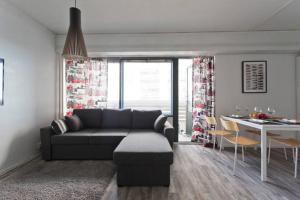 a living room with a couch and a dining room at Seaside Downtown Apartment in Helsinki