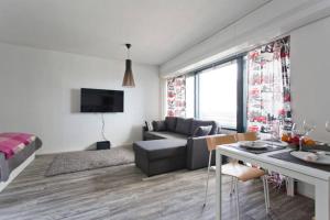 a white living room with a couch and a table at Seaside Downtown Apartment in Helsinki