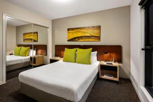 ein Hotelzimmer mit 2 Betten und grünen Kissen in der Unterkunft Quest Docklands in Melbourne