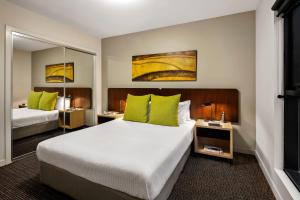 a hotel room with two beds with green pillows at Quest Docklands in Melbourne