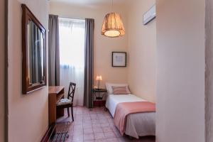 a small room with a bed and a window at Hotel d'Azeglio Firenze in Florence