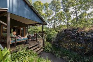 two people sitting on the porch of a house at Spicers Tamarind Retreat in Maleny