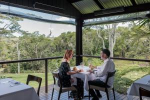 um homem e uma mulher sentados numa mesa num restaurante em Spicers Tamarind Retreat em Maleny