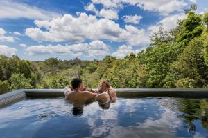 a man and a woman sitting in a hot tub at Spicers Tamarind Retreat & Spa in Maleny