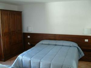 ブリュソンにあるAgriturismo Les Hibouxのベッドルーム1室(青い毛布付きのベッド1台付)