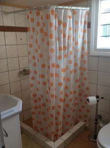 a bathroom with a shower curtain with an orange at Toula's House in Spetses