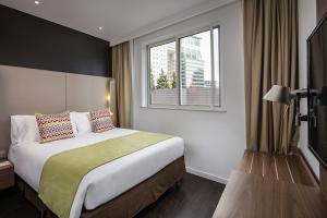 a hotel room with a bed and a window at Campanile Shanghai Bund Hotel in Shanghai