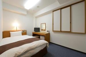平冢市3s HOTEL HIRATSUKA的一间卧室，配有一张床和一张带电脑的书桌