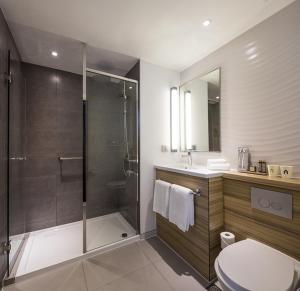 a bathroom with a shower and a toilet and a sink at Campanile Shanghai Bund Hotel in Shanghai