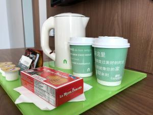 three coffee cups and a box on a green tray at Campanile Shanghai Bund Hotel in Shanghai