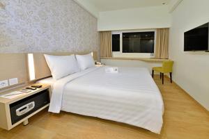Ένα ή περισσότερα κρεβάτια σε δωμάτιο στο Whiz Prime Hotel Sudirman Cilacap